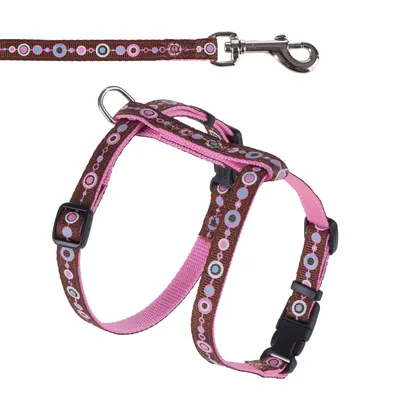 Pettorina marrone e rosa con motivo a cerchi e guinzaglio abbinato, chiusura in metallo e cinghie regolabili. Pettorina marrone e rosa con motivo a cerchi e guinzaglio abbinato, chiusura in metallo e cinghie regolabili.