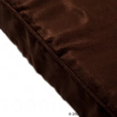 Close-up of a brown, soft fabric cover with a smooth surface, possibly for a cushion or mattress.