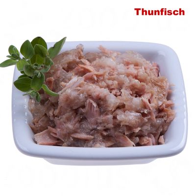 Schale mit zerkleinertem Thunfisch, dekoriert mit frischen grünen Kräutern. Text 'Thunfisch' oben rechts in roter Schrift.