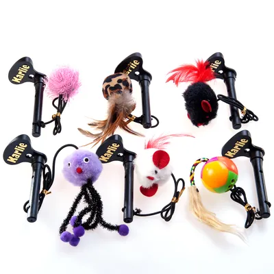 Juguetes para gatos con varilla negra Karlie y diferentes figuras: pelotas, ratones de tela, pompones, plumas y cuerdas. Marca Karlie visible en cada varilla.