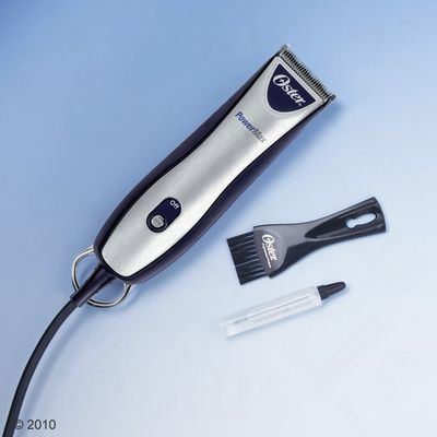 Oster PowerMax klippemaskine med on/off-knap, sort børste med Oster-tekst og lille tube olie. Alle dele synlige på lys baggrund.