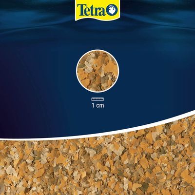 Tetra vlokkenvoer, detailopname van de vlokken met aanduiding: 1 cm. Merknaam Tetra zichtbaar bovenaan.