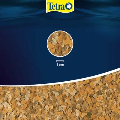 Tetra vlokkenvoer, detailopname van de vlokken met aanduiding: 1 cm. Merknaam Tetra zichtbaar bovenaan.