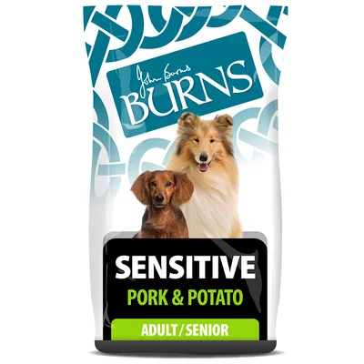 Упаковка корма для собак Burns Sensitive Pork & Potato, надписи: SENSITIVE, PORK & POTATO, ADULT/SENIOR, изображены две собаки на переднем плане.