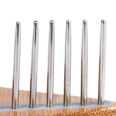 Close-up van een kam met lange metalen tanden en een houten handvat. Geschikt voor vachtverzorging.