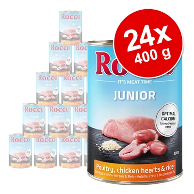 Rocco Junior, 24 konzerv po 400 g. Vidno: perutnina, piščančja srca in riž. Oznaka: optimalno razmerje kalcija in fosforja. Besedilo v angleščini: Poultry, chicken hearts & rice.