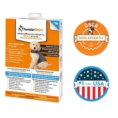 ThunderShirt verpakking met afbeelding van hond in grijze jas. Zichtbare tekst: 'ÜBER 80% EFFEKTIV', '#1 in den USA'. Meertalige productinformatie op de doos.