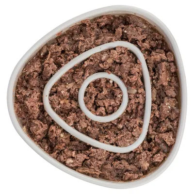 Gros-plan al hranei umede maro într-o caserolă triunghiulară din plastic cu design în spirală.