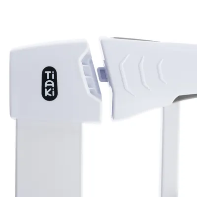 Détail du mécanisme de fermeture d'une barrière blanche en plastique avec le nom Tiaki visible sur le côté gauche.