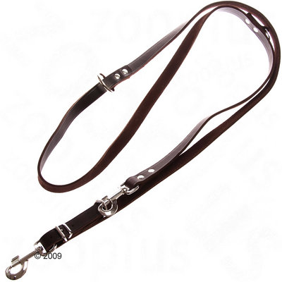 Adjustable brown leather lead with metal clips and rings, showing multiple attachment points for length adjustment. Adjustable brown leather lead with metal clips and rings, showing multiple attachment points for length adjustment.