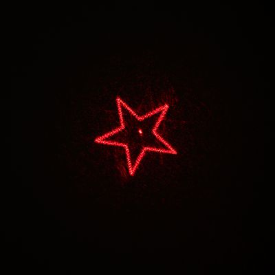Punainen tähti laserprojisointina mustalla taustalla.