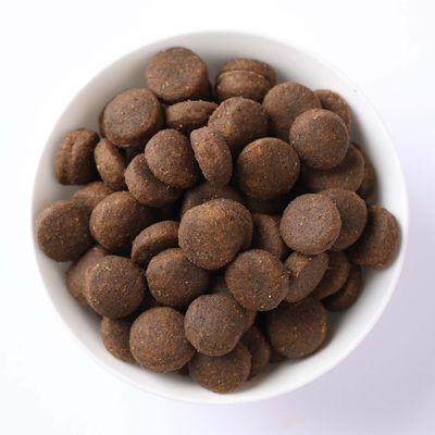 Miska s okrúhlymi, hnedými granulami suchého krmiva.