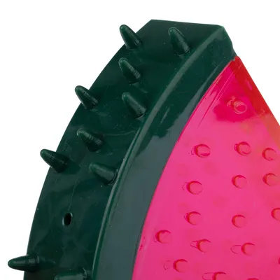 Detailní záběr na zelenou a růžovou hračku s nopky a hroty z plastu.