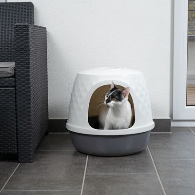 Cat sitting inside a covered litter box with a white top and grey base, showing product in use indoors.