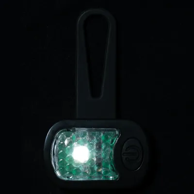Lampe LED noire avec bouton marche, lumière blanche allumée, attache en plastique visible pour fixation.
