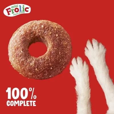 Mini Frolic, naturalmente irresistible. En la imagen: snack marrón en forma de donut y huellas blancas. Texto: 100% Complete.