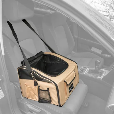 Beige Transporttasche mit Netzfenstern und Taschen, befestigt auf einem Autositz mit Sicherheitsgurten.