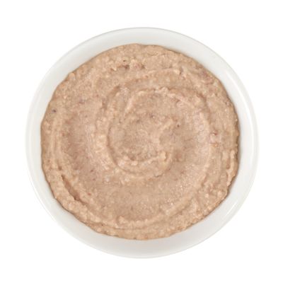 Skål med krämigt våtfoder, beige-brun färg, slät och jämnt fördelad.