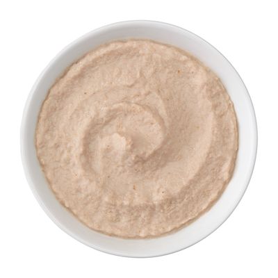 Närbild av krämig, ljusbrun pastej i en vit skål.