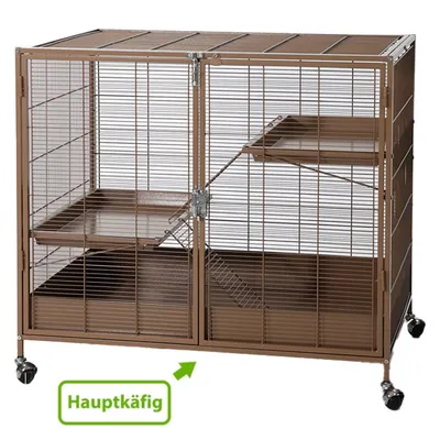 Cage principale en métal marron à roulettes avec deux étages, rampes et plateforme. Texte allemand visible : Hauptkäfig.