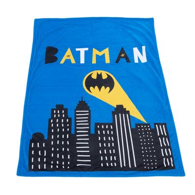 Niebieski koc z logo Batman, żółtym reflektorem i motywem panoramy miasta.