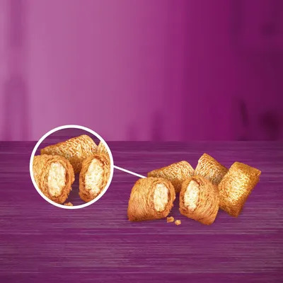 Detailní záběr na křupavé snacky s krémovou náplní, prezentované na fialovém pozadí.