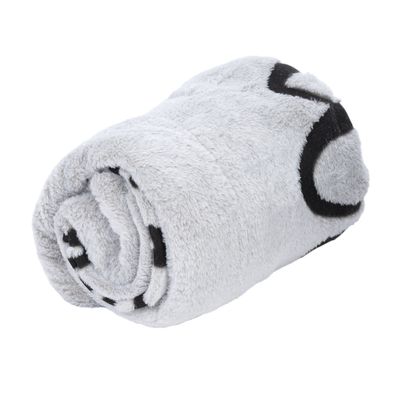 Coperta grigia arrotolata con motivi neri. Materiale morbido visibile.