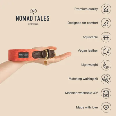 NOMAD TALES München collar held in hand, visible label. Text: Premium quality, Designed for comfort, Adjustable, Vegan leather, Lightweight, Matching walking kit, Machine washable 30°, Made with love.