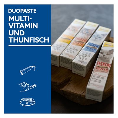 GimCat DuoPaste multivitamin in tuna. Proti kepam dlak, slad z piščancem. Prikaz štirih past na leseni podlagi.