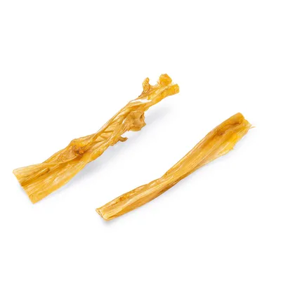 Zwei naturbelassene Kausnacks aus getrocknetem Material, länglich und gelblich-braun. Zwei naturbelassene Kausnacks aus getrocknetem Material, länglich und gelblich-braun.