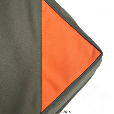 Detailný pohľad na dvojfarebný textilný materiál v zelenej a oranžovej farbe, vhodný na zvieracie doplnky alebo čalúnenie.