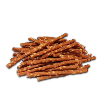 A stack of brown, elongated dog snacks with visible white spots.