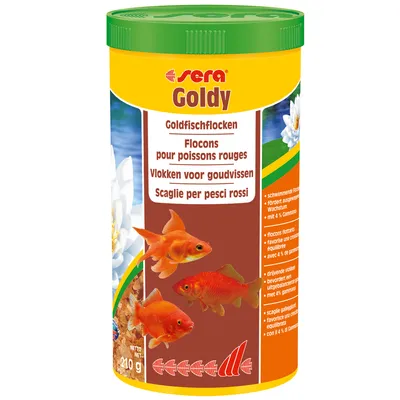 Embalagem de Sera Goldy, flocos para peixes dourados. Texto visível em vários idiomas e imagem de três peixes dourados. Peso líquido: 210 g.