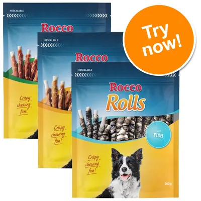 Three packs of Rocco Rolls dog treats, resealable, visible text: 'Crispy chewing fun!', 'with FISH', each 200g. Large orange circle with 'Try now!'. Border collie image on front pack.