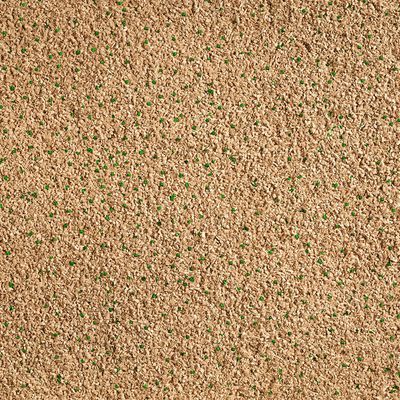 Close-up van bruin kattenbakvulling granulaat met kleine groene deeltjes, materiaalstructuur duidelijk zichtbaar.