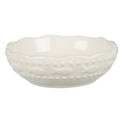 Vit keramikskål med vågig kant och upphöjt fiskmönster runt om. Ingen synlig text eller varumärke.