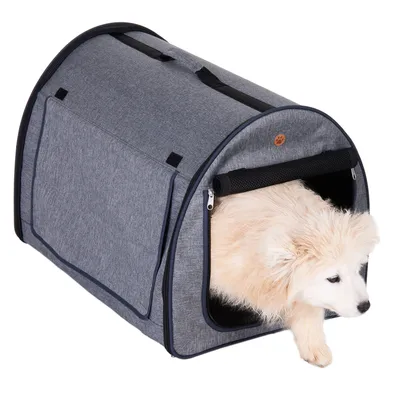 Niche ou caisse de transport en tissu gris avec un chien blanc à poils longs sortant par l’ouverture avant zippée. Poignée visible sur le dessus.