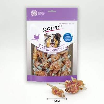 Dokas Hühnerbrust mit Fisch hondensnack, verpakking met zichtbare stukjes kip en vis, maatindicatie ~6 cm. Tekst op verpakking in het Duits.