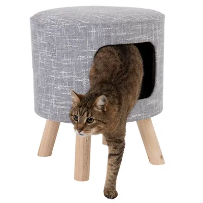 Taburete gris con patas de madera y escondite integrado para gatos. Gato saliendo de la abertura.