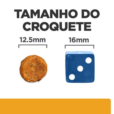 Tamanho do croquete: 12,5 mm de diâmetro ao lado de um dado azul com 16 mm. Comparação visual para referência de dimensão.