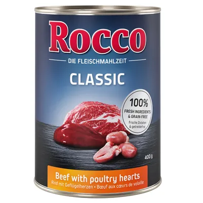 Konzerva Rocco Classic, 400 g. Text: 100% fresh ingredients & grain-free. Beef with poultry hearts. Die Fleischmahlzeit. Na obrázku kus masa a drůbeží srdce.