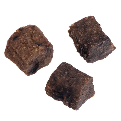 Tři hnědé, kostkovité pamlsky z masa nebo podobného materiálu.