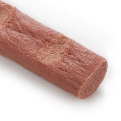 Närbild av en köttfärgad snacksticka med slät textur och rundade ändar.
