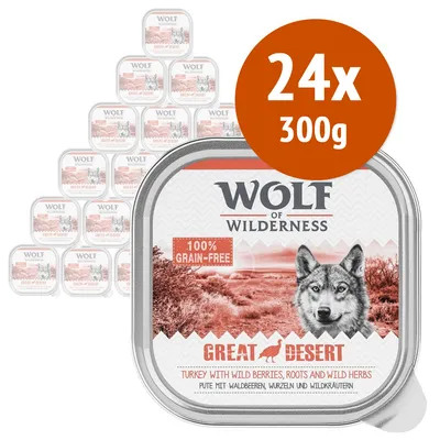 Wolf of Wilderness Great Desert, 24x300g, 100% grain-free. Tacchino con frutti di bosco selvatiche, radici ed erbe selvatiche. Confezioni visibili impilate sullo sfondo.