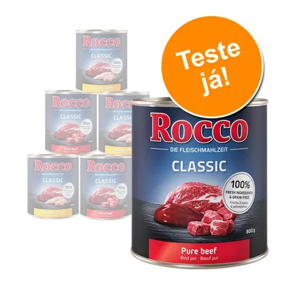 Latas de comida Rocco Classic, destaque para variedade Pure beef 800 g. Texto visível: '100% fresh ingredients & grain-free'. Selo laranja com texto 'Teste já!'. Latas de comida Rocco Classic, destaque para variedade Pure beef 800 g. Texto visível: '100% fresh ingredients & grain-free'. Selo laranja com texto 'Teste já!'.