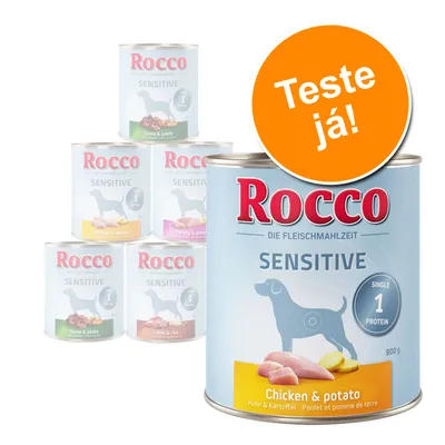 Latas de comida húmida para cão Rocco Sensitive, sabores visíveis: Chicken & potato, Game & pasta, Turkey & potato, Lamb & rice. Texto em destaque: Teste já!