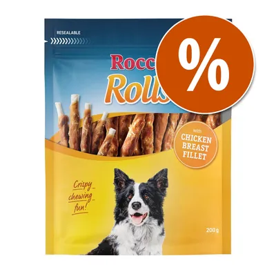 Bolsa de snacks Rocco Rolls con texto visible: 'with chicken breast fillet', 'Crispy chewing fun!', 200 g. Símbolo de porcentaje en círculo naranja indica oferta o descuento. Bolsa de snacks Rocco Rolls con texto visible: 'with chicken breast fillet', 'Crispy chewing fun!', 200 g. Símbolo de porcentaje en círculo naranja indica oferta o descuento.