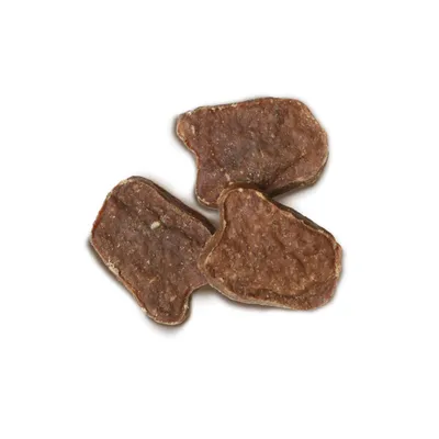 Tre brune, flade hundesnacks i uregelmæssig form, synlige uden emballage.