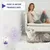 Difusor Feliway Optimum enchufado, gato gris mirando y texto: PARA LA MEJOR TRANQUILIDAD. Mujer sentada en sofá al fondo.
