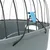 Détail d’une cage en métal noir et plastique gris avec attache bleue et corde noire visible sur le côté supérieur.